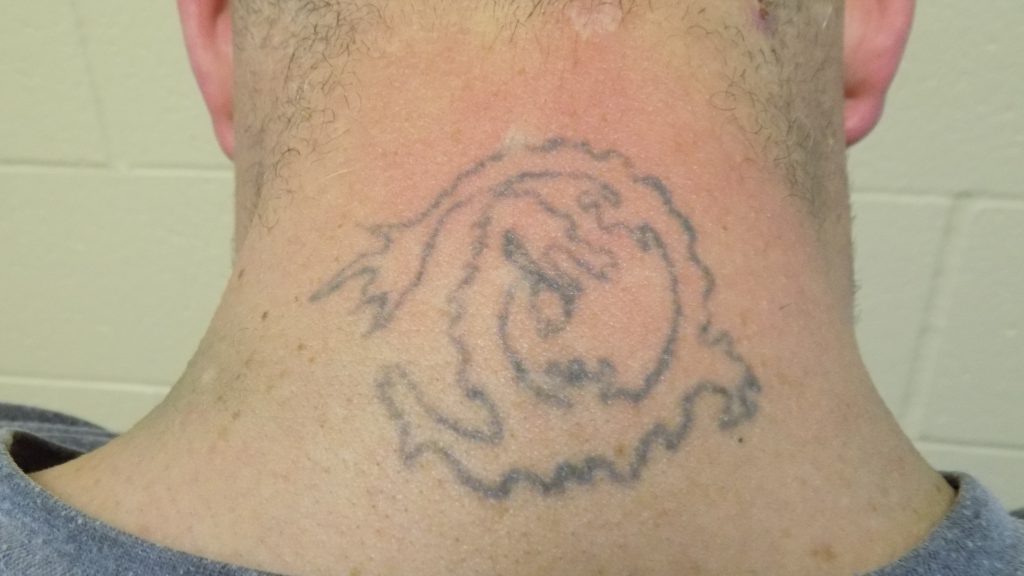Pictured: tattoo on the back of suspect's neck.
