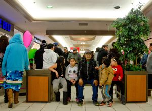 An elder and four children sit in the middle of the round dance circle at the Lloyd Mall on Friday evening. Photo by James Wood/106.1 The Goat/Vista Radio 