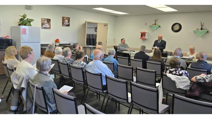MLA Colleen Young seated far left listens to president Graham Brown delivering his report at the Lloydminster Concerned Citizens for Seniors Care AGM. | Photo: Gerry Lampow 106.1 The Goat/Vista Radio.