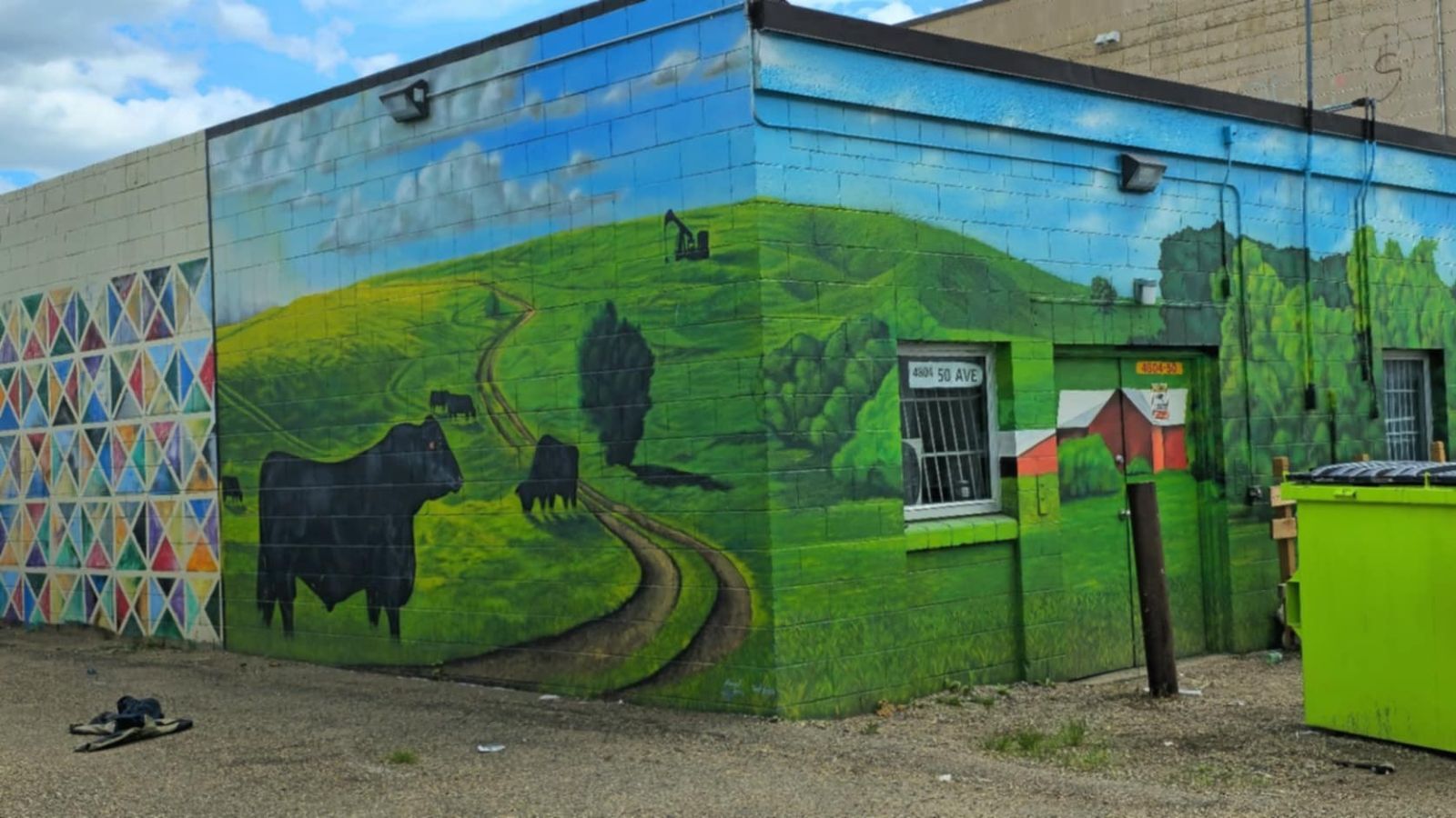 Artwork in Lloydminster alleyway with clothing on the ground.
