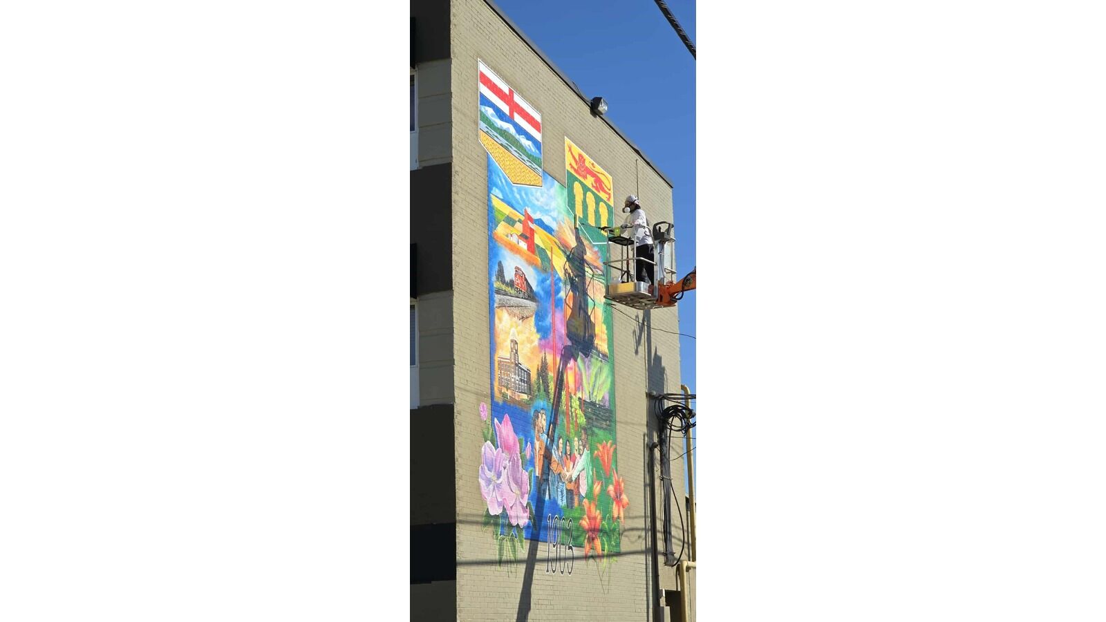 Artist Harwell Teves applying clearcoat to seal the deal on his latest mural in downtown Lloydminster.