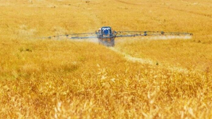 Farmer spraying a field.